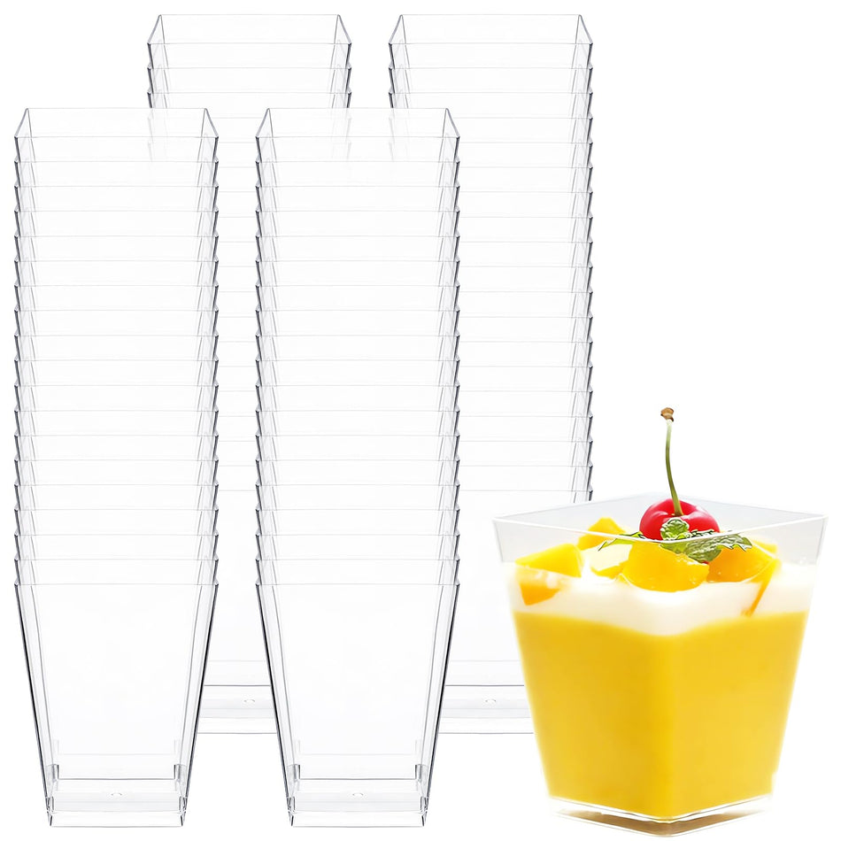 Clear plastic cups stacked with a glass of yellow dessert with a cherry on top.