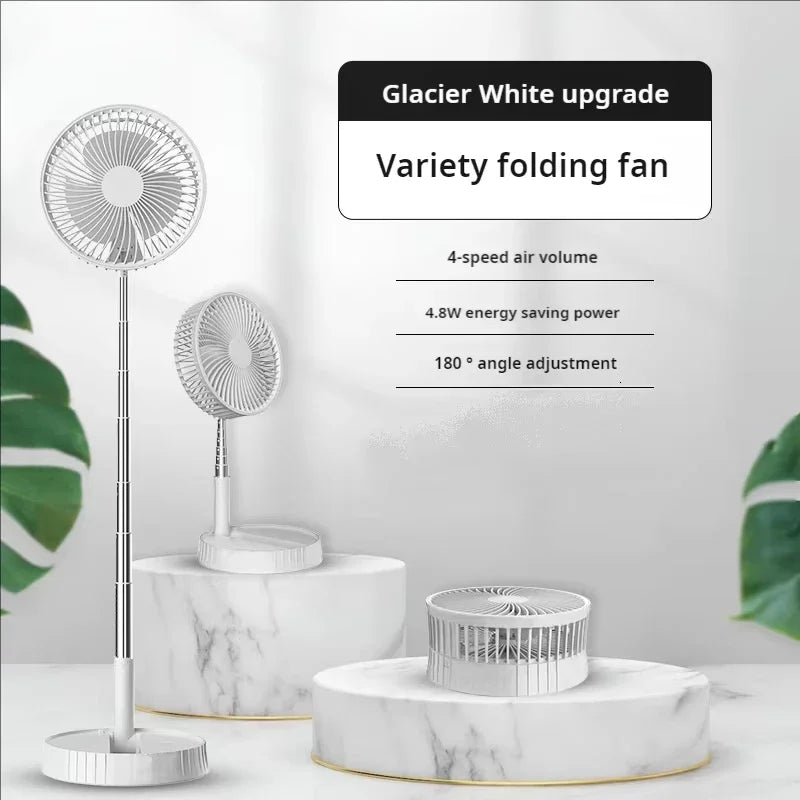 White folding fan with remote control on a marble base, surrounded by green leaves.