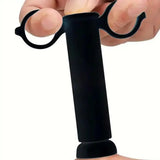 Black finger exerciser held by a hand on a white background