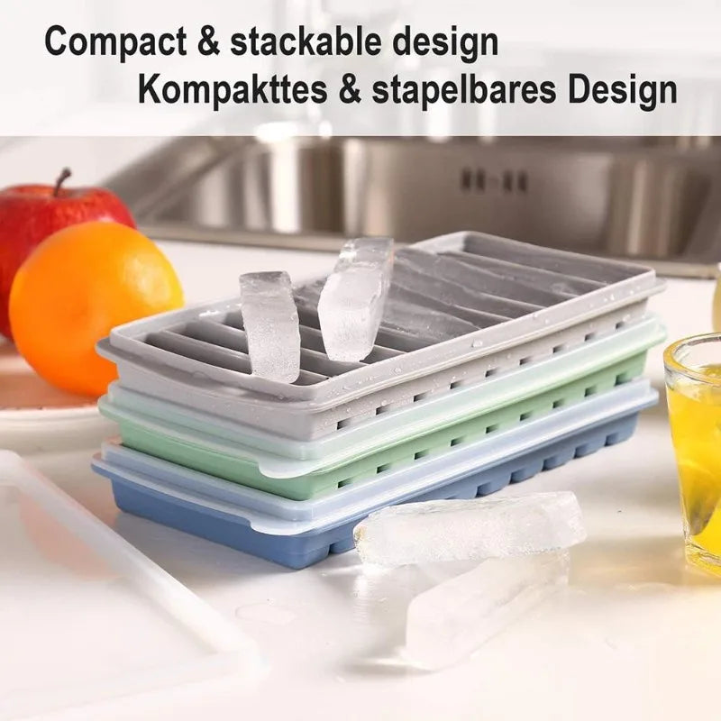 Stackable silicone trays on a kitchen counter with fruits and a glass.